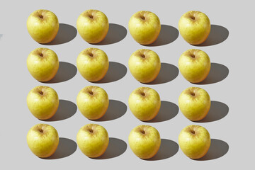 Colourful pattern of apples on grey background. View from top.