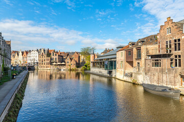 Fototapeta na wymiar Downtown brick houses, river and moored boat Ghent, Belgium