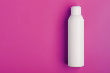 White bottle on pink background. Free space for text.