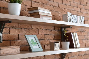 Shelves with decor on brick wall