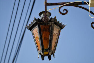 Fototapeta na wymiar Retro iron lamp hang from a wall. hanging lantern on the street. street lamp. romantic light.