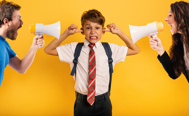 Student Child covers his ears because he does not want to hear reproach of the parents. Yellow...