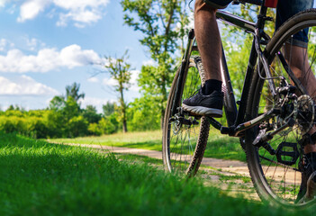 A young man rides a Bicycle on country roads close up copy space