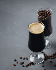 Craft coffee stout beer in a glass and roasted coffee beans copy space