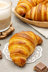 Freshly baked croissants with coffee on a gray background