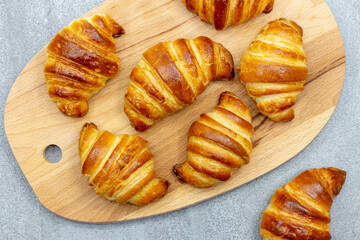 Fresh croissants on a wooden board
