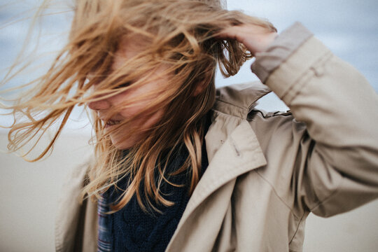 portrait of a ginger-haired blond small adorable girl with hair fluttering in the wind