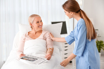 Fototapeta premium Female doctor working with patient in hospital room