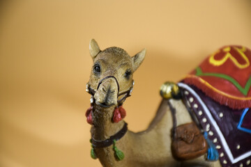 Small statue of a miniature camel in a sand colored field
