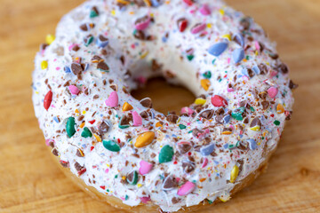 Donut in white glaze with colored sprinkles
