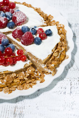 healthy sweet oatmeal cake with yoghurt and fresh berries on white table, vertical top view