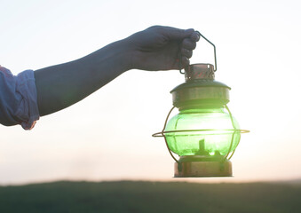 Antique antique lamp in a hand. Against the sky. Sunset. Lamp
