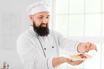 Male chef with tasty pasta carbonara in kitchen