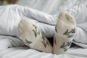 A man in warm socks under a blanket.
