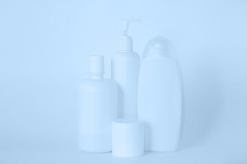 White plastic bottles with cosmetics on white background. Still life.