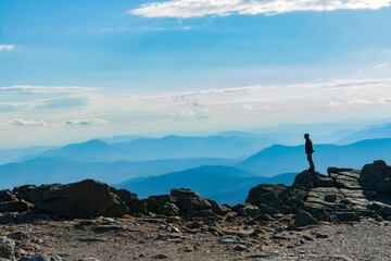 View from top Mount Washington across mountainous landscape to horizon.
