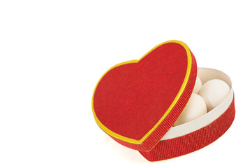 Chic red heart-shaped box, half-opened with eggs seen in it, on white background