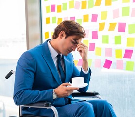 Young handsome man in wheelchair with many conflicting prioritie