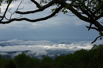 The sun is breaking through the dark clouds as the storm passes.
