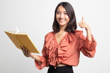 Young Asian woman thumbs up with a book .