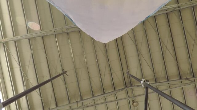 A Big Bag Lifted And Transported By A Forklift In An Industrial Warehouse - close up undershot