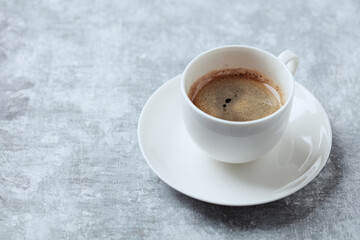 Cup of coffee on bright wooden background. Copy space.
