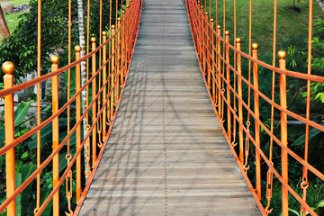 Hanging Red (orange) wooden bridge over the river in summer, Bali, Indonesia