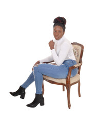 Fototapeta na wymiar Tall African American woman sitting sideward in an old armchair