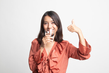 Young Asian woman thumbs up with a glass of drinking water .