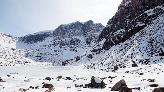 Winter mountain hiking in the snow at the Triple Buttress of Coire Mhic Fhearchair on the Isle of Skye in the Scottish Highlands of the UK.