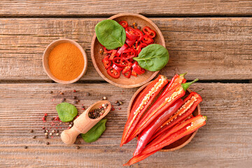 Hot chili pepper and spices on wooden background