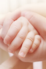 Hands of the baby and his mother