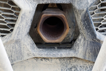 Rear view of the Exhaust pipe of a dirty UTV buggy.