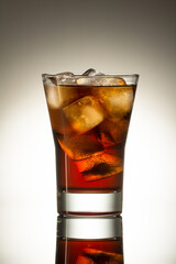 glass with cola on a glossy surface