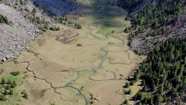 Flying over Natural Water Stream in Adamello National Park.
Aerial View of Mountain Creek. Travelling Clouds. Mountain Landscape.