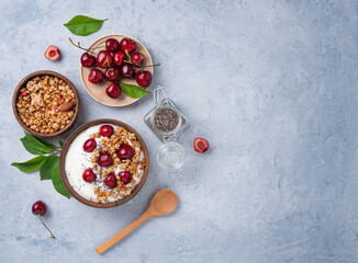 natural  fermented yogurt with granola, chia seeds and  fresh cherry  on light  table