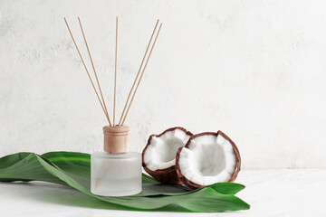 Reed diffuser and coconut on table