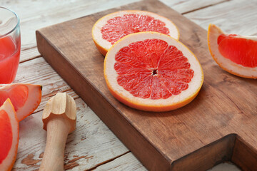 Cutting board and sliced fresh grapefruit on table