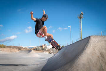 hombre joven hace un salto desde una rampa en un skate park.