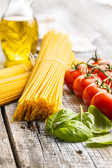 Raw spaghetti pasta, cherry tomatoes, basil leaves and olive oil.