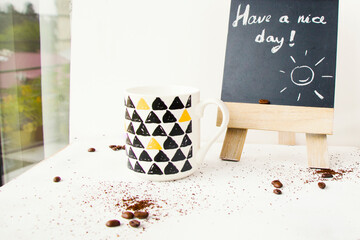 Coffee beans, cup and have a nice day text and letter on the black board, studio shoot ,on the white background