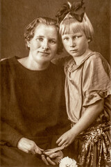 Germany - CIRCA 1930s: Portrait of mother and daughter sitting at bench in studio, Vintage Carte de Viste Art Deco era photo