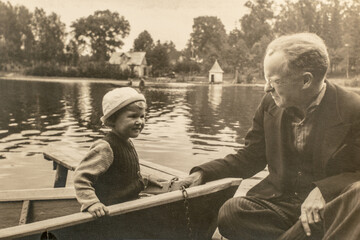 Latvia - CIRCA 1930s: Portrait of daughter and father in the boat. Vintage archive Art Deco era photography