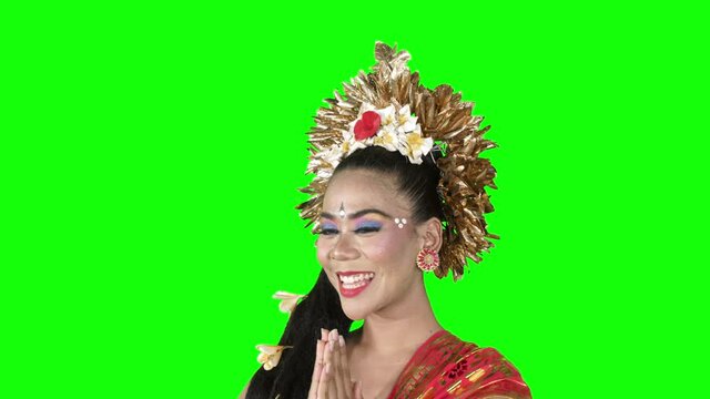 Happy balines dancer showing welcome gesture while smiling at the camera in the studio. Shot in 4k resolution with green screen background