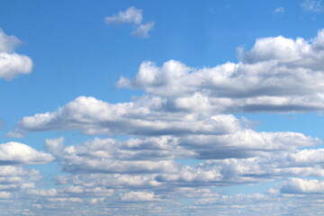 White fluffy clouds on a background of blue sky in summer. The concept of weather and climate