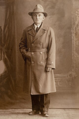 Germany - CIRCA 1930s: Man in coat portrait standing in studio Vintage art deco era photo
