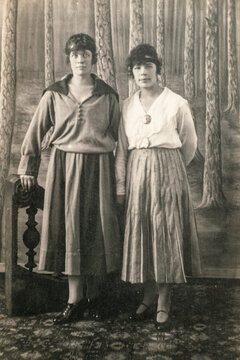RUSSIA - CIRCA 1910s: Full body shot of two young women in studio Vintage Carte de Viste Edwardian era photo
