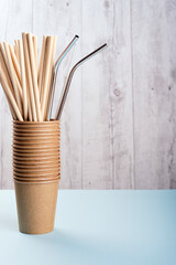 Paper and stainless steel drinking straws are in brown cups. 