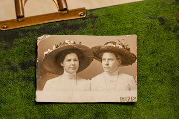 Germany - CIRCA 1912: Photo of two young women wearing hats on green background. Vintage Carte de Viste Edwardian era photo