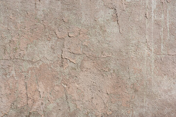 Texture of old concrete wall with flaky beige paint, cracks and attritions. Abstract grunge background.